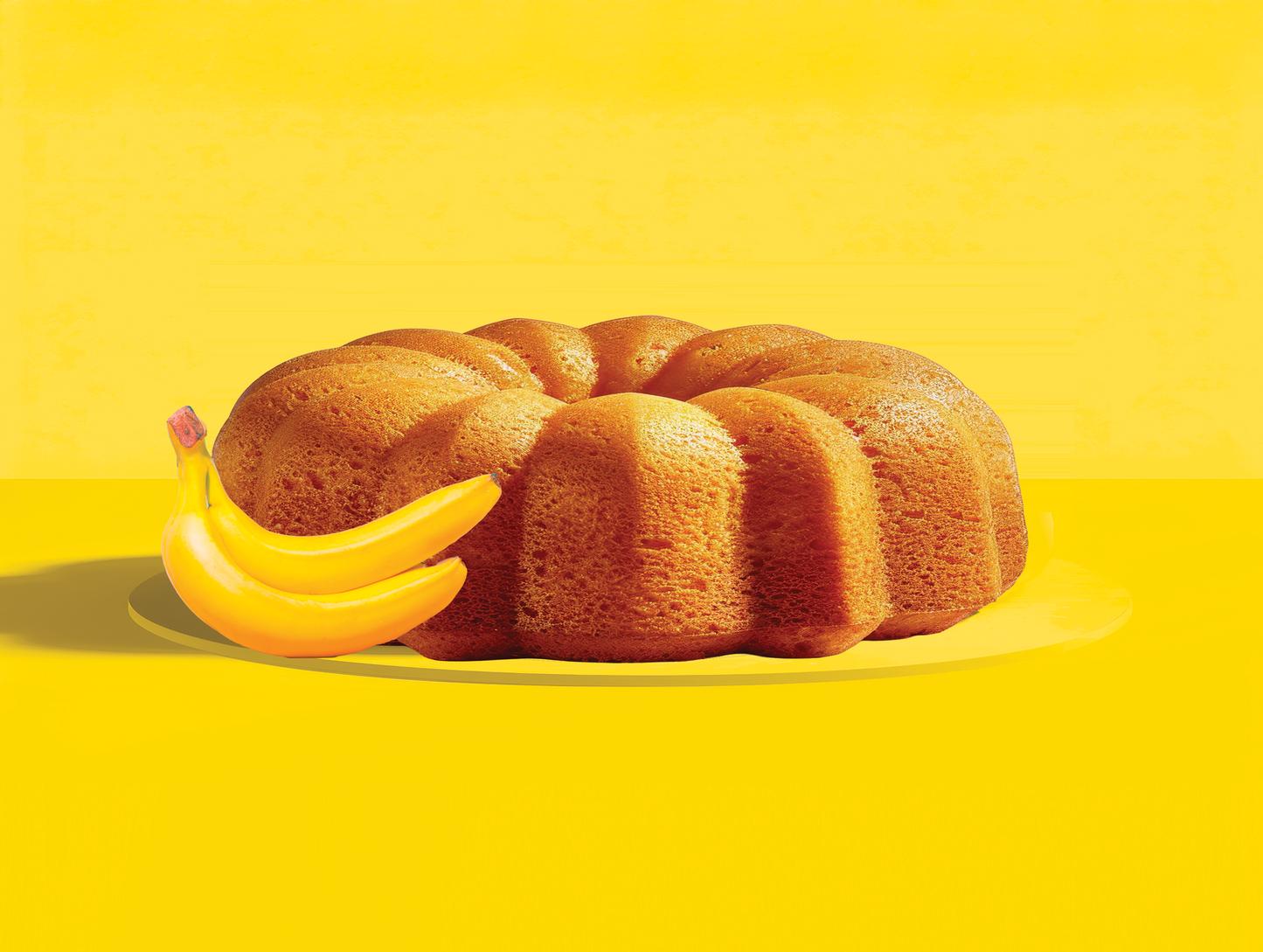 Bundt cake with bananas on a yellow background