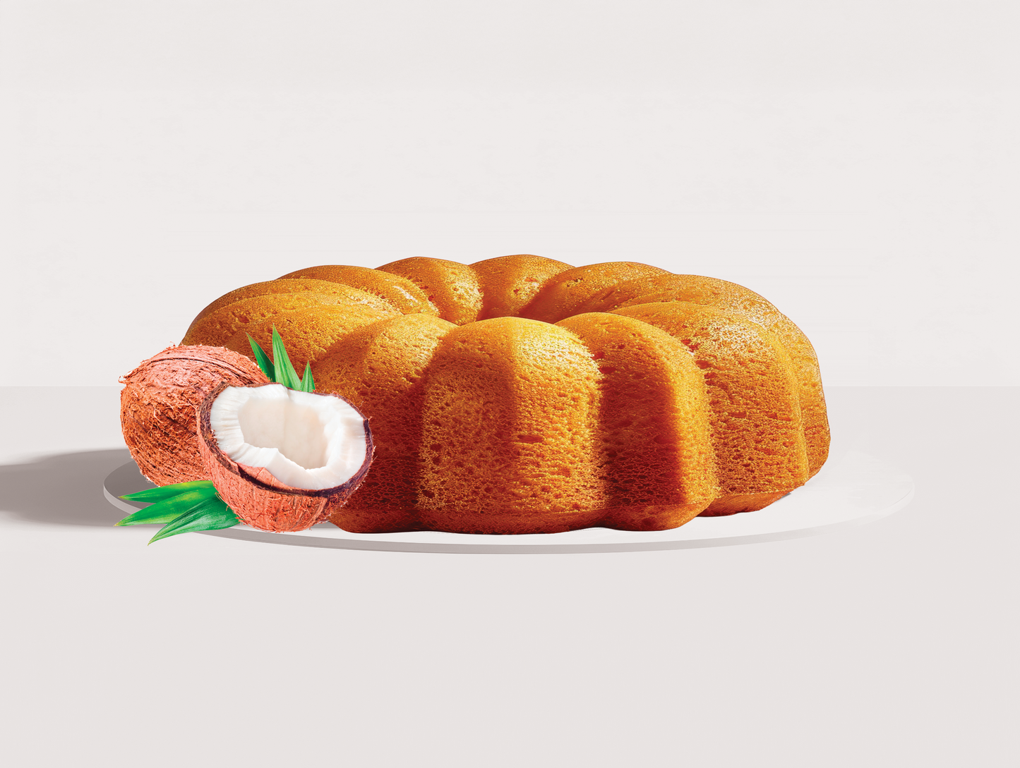 Bundt cake with decorative carrot and carrot top on a white background