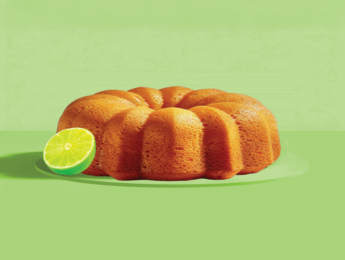 Key Lime Bundt cake with a lime on a green background