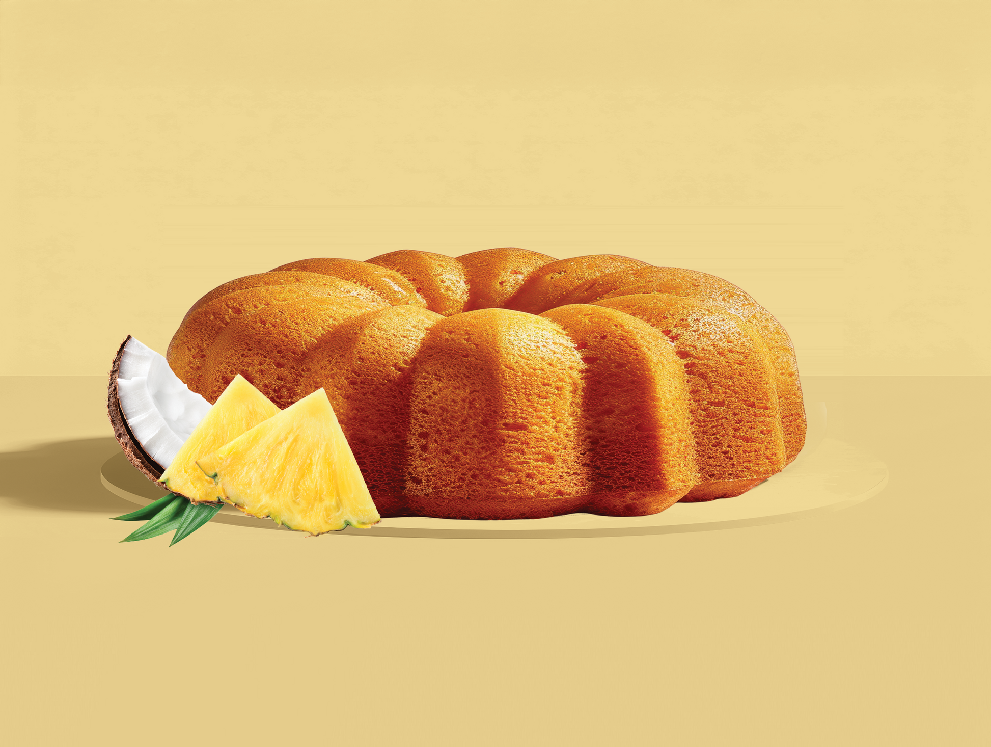 Pineapple and coconut bundt cake with pineapple slices on a beige background